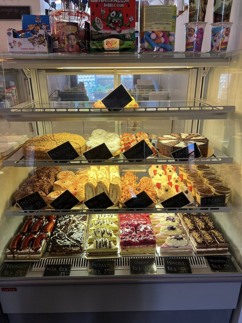 Výloha cukrárny plná domácích zákusků a dortů